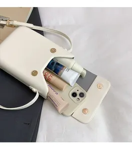 Detail view of the cream white PU leather crossbody phone bag showing interior capacity