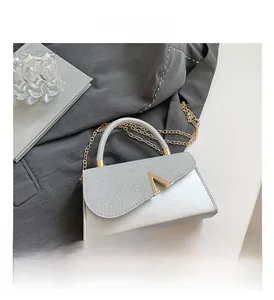 Detailed macro view of the silver crossbody bag showing the matte leather and glitter texture