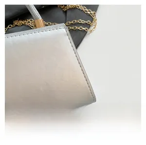 Close-up of silver handbag showing pearl luster texture and fine white stitching details