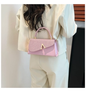 Detailed back view of pink sequined crossbody bag with gold chain and V-shaped clasp