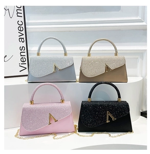 Detail showing four glitter square bags with V-shaped metal buckles and chain straps
