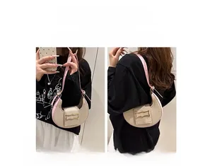 Sac demi-lune beige minimaliste montrant les styles porté main et épaule