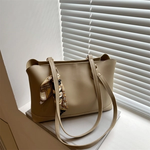 Minimalist beige tote bag with floral scarf decor on a windowsill with sunlight
