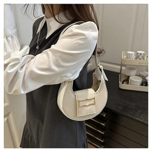 Détail du sac demi-lune blanc cassé avec texture tressée et fermoir doré