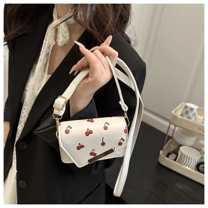 Detailed view of white PU leather crossbody bag with cherry prints and golden metal bar
