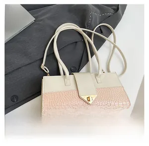Détails de la texture crocodile et boucle dorée en V sur un sac à main élégant
