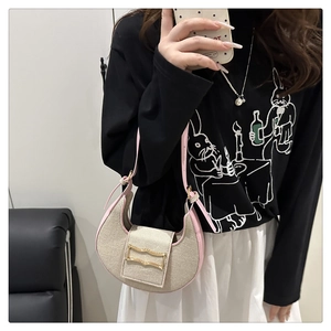Détail du sac croissant en toile avec bordure en cuir rose et boucle dorée décorative