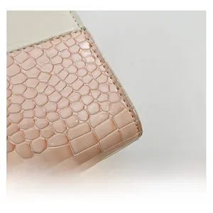 Gros plan détaillé montrant les coutures du cuir beige et la texture croco rose