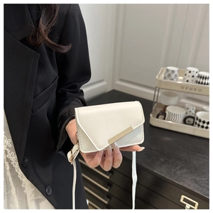 Detail of off-white crossbody bag featuring an asymmetrical flap and gold metal bar buckle