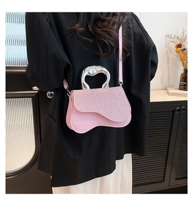 Detail of light pink asymmetric bag featuring sparkling sequins and metallic handle