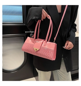 Détail du sac à main rose façon crocodile avec fermoir élégant en métal doré en forme de V