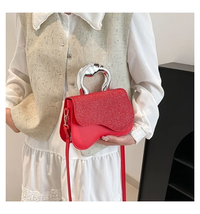 Macro shot of red sequin flap and wavy edge on crossbody bag with silver handle