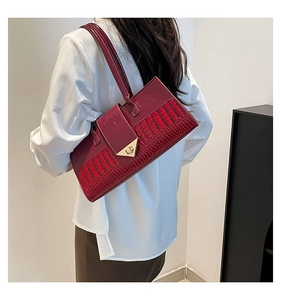 Détail du sac baguette bordeaux à motif crocodile et fermoir métallique doré