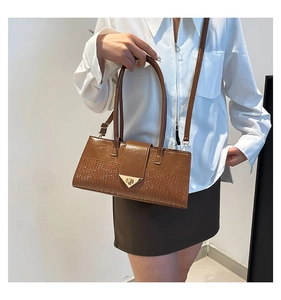 Gros plan du sac à main marron avec motif crocodile et fermoir triangle doré chic