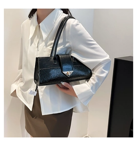 Détail du sac baguette noir aspect crocodile avec fermoir triangulaire en argent chic