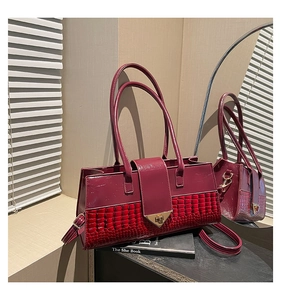 Vue détaillée du sac bordeaux motif crocodile avec fermoir triangulaire en métal poli
