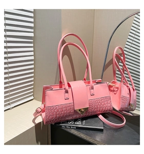 Détail du sac rose avec relief crocodile et boucle métallique dorée élégante en gros plan