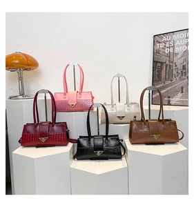 Détail de cinq sacs à main élégants avec patchwork motif crocodile sur supports modernes