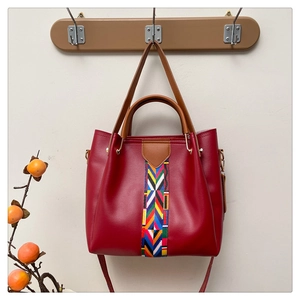 Rote Handtasche aus glattem Leder mit bunten Webstreifen und braunen Doppelgriffen