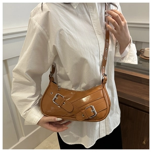 Détail du sac porté épaule en cuir verni caramel avec boucles argentées et style Y2K biker