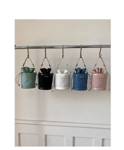 Close-up of stylish bucket bags in five colors with textured finish and drawstring