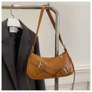 Détail du sac porté épaule en cuir verni caramel avec boucles de style vintage