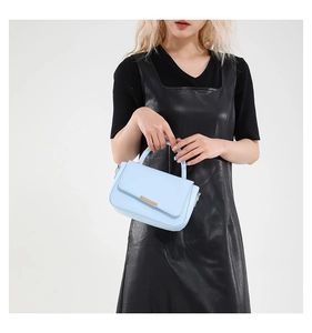 Detailansicht der hellblauen Lederhandtasche mit minimalistischen goldenen Metallteilen