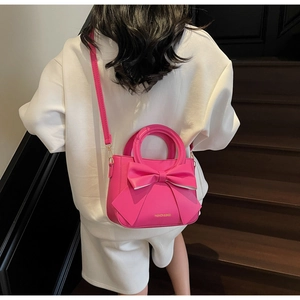 Vue arrière du sac à main en cuir rose avec nœud sur mannequin près d'un escalier