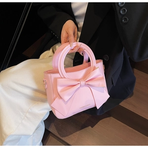 Détail du sac à main en cuir PU rose avec grand nœud et texte doré mode imprimé