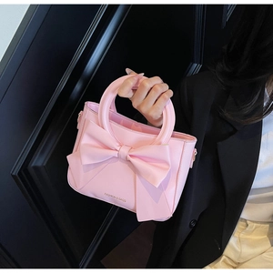 Détail du grand nœud et du logo imprimé sur le sac à main rose pour femmes