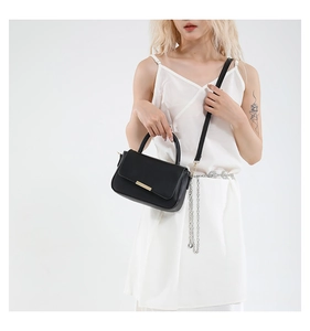 Détails du sac à main noir minimaliste avec fermoir doré et bandoulière polyvalente