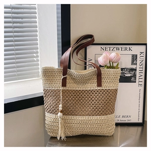 Détail du sac cabas en paille tressée avec maille ajourée et pompon à perles