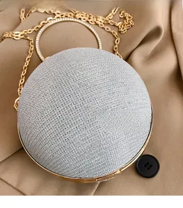 Détail du tissu pailleté argenté et de la poignée ronde en strass du sac de soirée