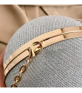 Détail macro du tissu pailleté argenté et du fermoir doré de cette pochette de soirée