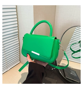 Detailansicht der leuchtend grünen Kunstledertasche mit silberner Metallverzierung