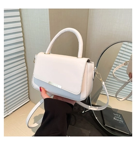 Detail der weißen Lederhandtasche mit silbernem Metallbesatz und elegantem Tragegriff