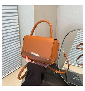 Braune Lederhandtasche mit Metalldetails und elegantem rundem Griff in Nahaufnahme