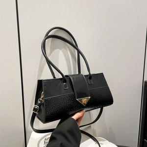 Sac à main noir texture crocodile avec fermoir triangle doré et épissage en cuir chic