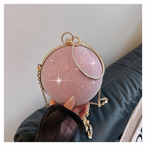 Détail du sac boule rose pailleté avec poignée anneau dorée et sa bandoulière chaîne