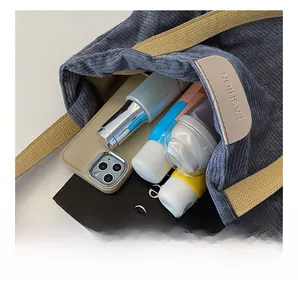 Macro view showing the large interior capacity and blue corduroy texture of the tote bag