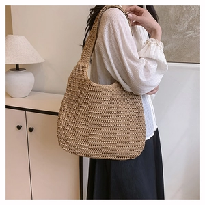 Détail du sac à bandoulière en paille marron clair avec tissage ajouré pour les tenues d'été