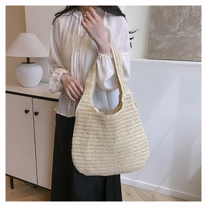 Détail du sac cabas en paille tressée beige montrant la texture et la grande capacité