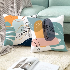 Peach skin pillow covers with green plant prints on a mint sofa in a modern cozy room