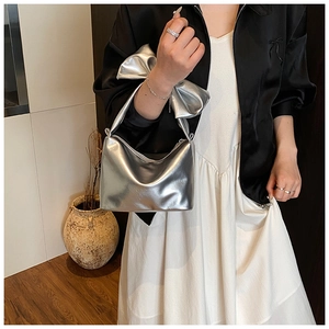Detail of silver metallic tote bag with oversized bow handle and top zipper closure