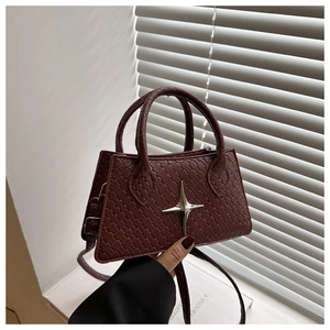 Detailed weave pattern on burgundy crossbody bag with silver star charm decoration