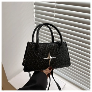 Close-up of black woven leather handbag with silver star buckle and twin handles