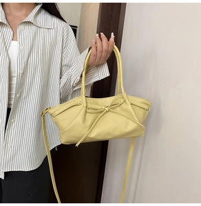 Detailed view of yellow tote bag featuring a leather texture and decorative bow knot