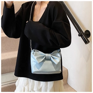 Light blue faux leather shoulder bag with a large bow and silver chain strap details