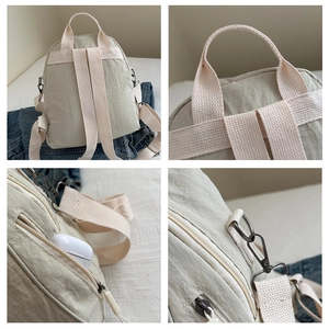 Dettagli dello zaino in nylon beige che mostrano il manico rinforzato e la tasca laterale