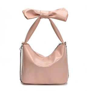 Pink patent leather tote bag featuring a large bow handle and silver chain strap